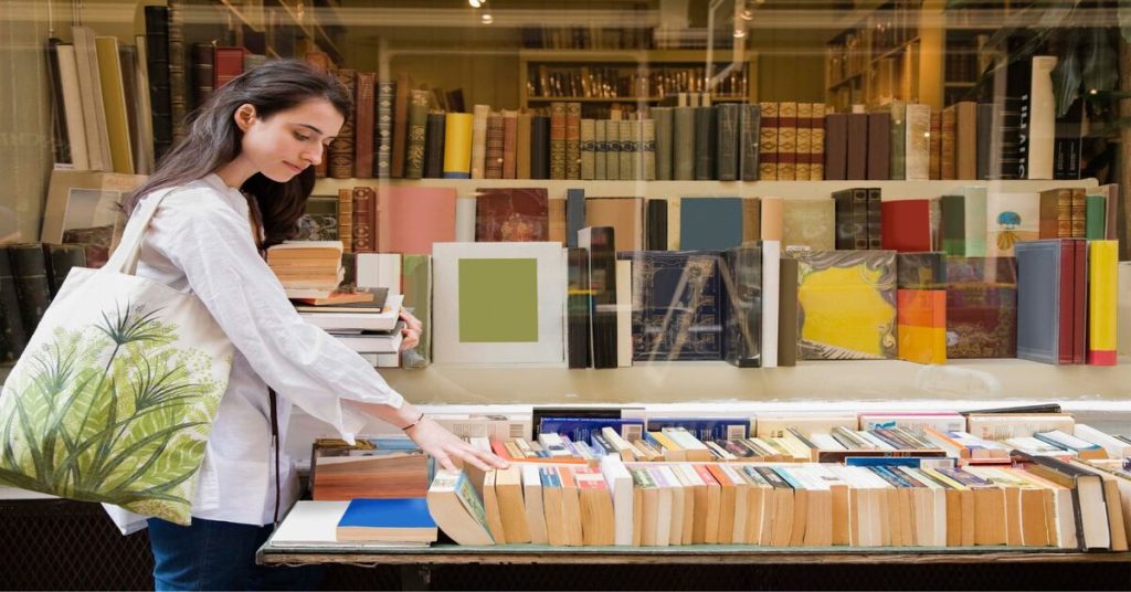 An individual browsing through a selection of books in a bookstore, which could represent education, leisure, and the literary world.